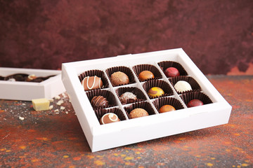 Box with delicious chocolate candies on grunge background