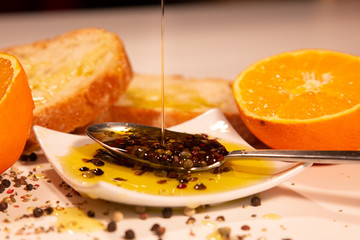 Cuchara con pimienta con aceite de oliva virgen y naranja 