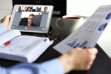 Fototapeta na wymiar Business woman talking to her colleagues in video conference. Business team working from home using digital tablet.