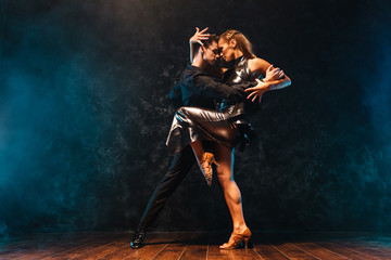 young couple in elegant evening dresses dancing - obrazy, fototapety, plakaty