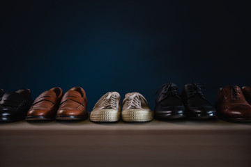 Men Footwear Fashion. Variety of Male’s Shoes on Shelf in House. included Sneaker, Wingtip, Loafer and Oxford
