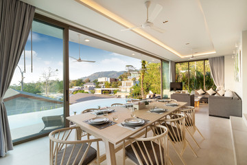 Interior design of dining area in pool villa, house, home, condo and apartment feature dining table, dining chair and open space living room
