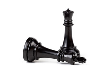 Chess pieces, death of a king, queen dominating the king standing above, piece laying on the ground below. Male female relationship issues, killer queen, rulers death, demise simple abstract concept