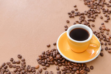 Cup of hot coffee and beans on table