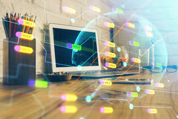 Double exposure of desktop with computer and world map hologram. International data network concept.