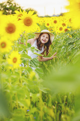 Obraz na płótnie Canvas Cute girl(child) playing in the sunflowers field with sunflowers.