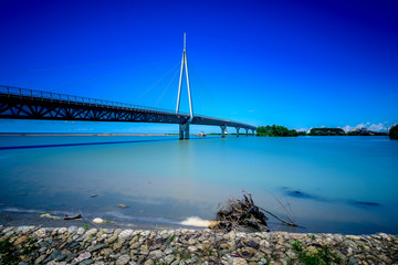 Naklejka premium A modern bridge connecting two islands with pastel blue skies