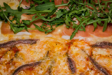 Pizza artigianale fatta in casa al forno con rucola acciughe salsiccia mozzarella pomodoro