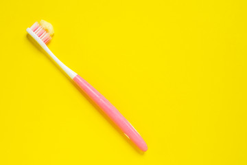 Bright pink and white tooth brush with paste.