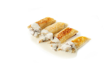 Thin pancakes with mushrooms and sauce isolated on the white
