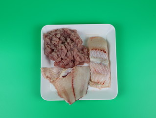 Fresh fish slices ready to cook isolated on  green background.