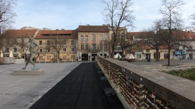 Footbridge with sculptures and padlocks empty during Coronavirus lockdown 2020 quarantine in Ljubljana, Slovenia. Forward dolly moving, wide shot
