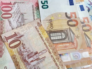 10 and 100 riyal,  50 and 20 Euro banknotes texture background.