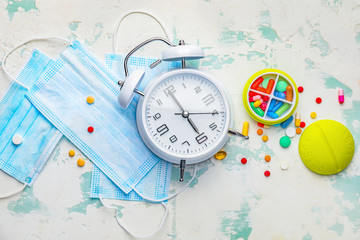 Composition with clock, masks and pills on light background