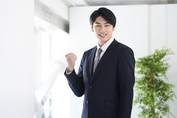 カメラ目線でガッツポーズをする日本人男性ビジネスマン