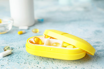 Box with different pills on table
