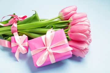 Gift and beautiful flowers on color background