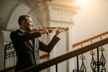 talented professional caucasian male violinist play in the hall, practice before performance....