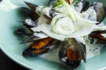 
Mussels cooked in a creamy sauce. Serving Close-up. Mediterranean Kitchen