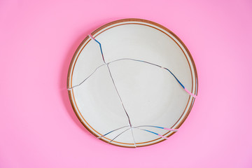 Broken plate on pink background