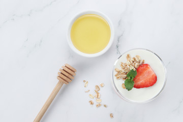 a cup of yogurt and strawberries on the table
