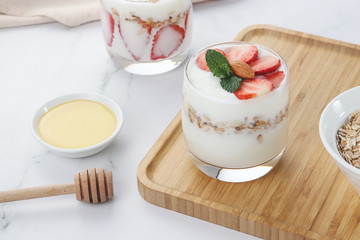 a cup of yogurt and strawberries on the table
