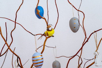 Osterdekoration Strauch mit Ästen, Vogel und bunten Ostereiern