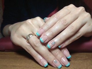 The manicurist excellently made her work a beautiful manicure with a polish gel on her hands and the client is happy