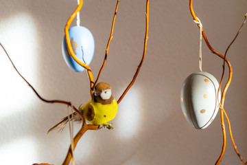 Osterdekoration Strauch mit Ästen, Vogel und bunten Ostereiern