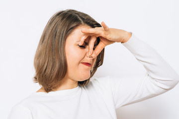 The stench. Closes the woman's nose