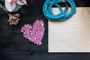 Valentine's day background - pink heart, flowers, blue beads mock up on a dark background