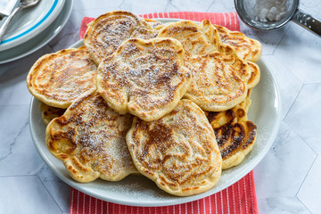 Fluffy homemade pancakes with apple dusted with icing sugar