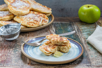 Fluffy homemade pancakes with apple dusted with icing sugar