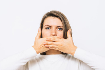 Successful stylish girl covers her mouth with her hands, isolated in the studio