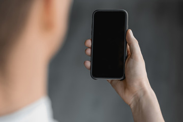 Businessman holding blank screen smartphone. Mockup concept