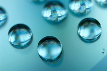 Drops of water on a compasc disc with blue filter in macro view