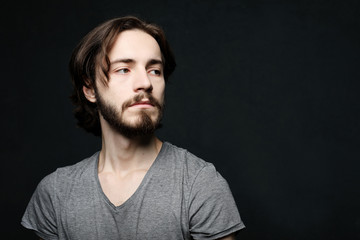 lifestyle and people concept: Portrait of handsome young bearded man on dark background