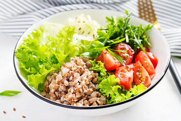 Healthy food. Buckwheat salad with cherry tomatoes, daikon, red onion and fresh herbs. Vegan food. Diet menu.