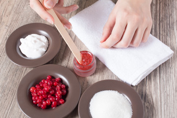 A woman makes a natural home scrub. Skin care. Natural ingredients for making a scrub, sugar, cream, berries. Moisturizing, exfoliating, peeling. Home Cosmetics, Spa Treatment, Aromatherapy, eco, 