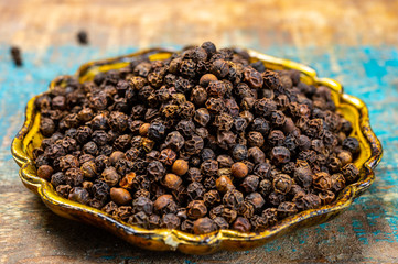 Bowl with dried black round peppers condiment