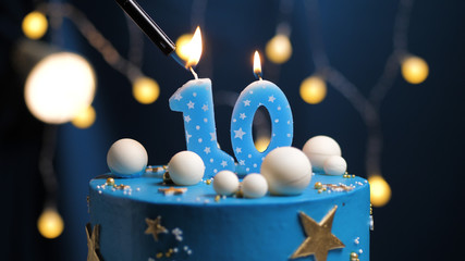 Birthday cake number 10 stars sky and moon concept, blue candle is fire by lighter. Copy space on...