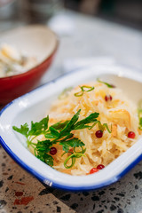Plate of a sauerkraut with a cranberry, decorated by a branch of a parsley