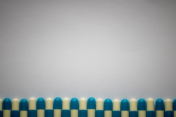 blue-white pills lined up against a plain background