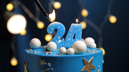 Birthday cake number 24 stars sky and moon concept, blue candle is fire by lighter. Copy space on...