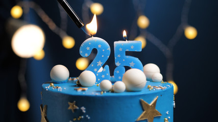 Birthday cake number 25 stars sky and moon concept, blue candle is fire by lighter. Copy space on...