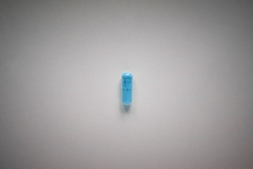 one blue pill on a plain background