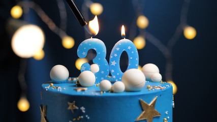 Birthday cake number 30 stars sky and moon concept, blue candle is fire by lighter. Copy space on...