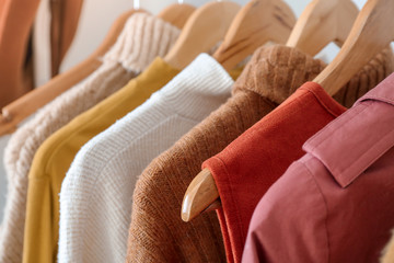 Modern clothes hanging on rack, closeup