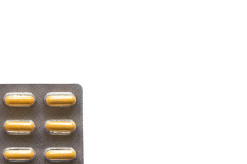 yellow pills in a blister on a plain background