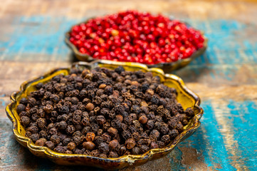 Bowl with dried black and red round peppers condiment